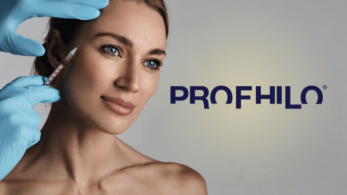 A woman with blue eyes and brown hair looks composed as a gloved hand applies a Profhilo injection to her cheek. The word "PROFHILO" is prominently displayed to the right of the woman on a light grey background.
