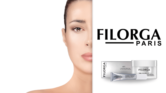 Close-up of a woman's face, with her left side visible. The right side of the image displays the text "FILORGA PARIS" and two skincare products: a tube labeled "ART UNIVERSAL" and a jar labeled "TIME-FILLER 5XP." Ideal for targeting dryness, these products sit against a white background.