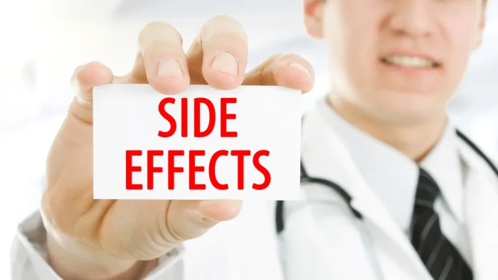 A doctor in a white coat holds a card with the words "SIDE EFFECTS" in red text.