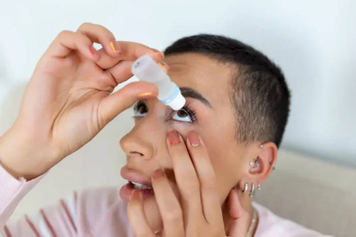 Person putting eye drops.