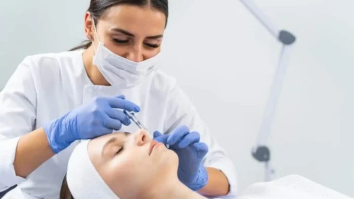 Lady injecting a person's face.
